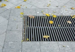 159413213-grating-of-the-drainage-storm-system-on-the-pedestrian-park-sidewalk-made-of-gray-stone-granite